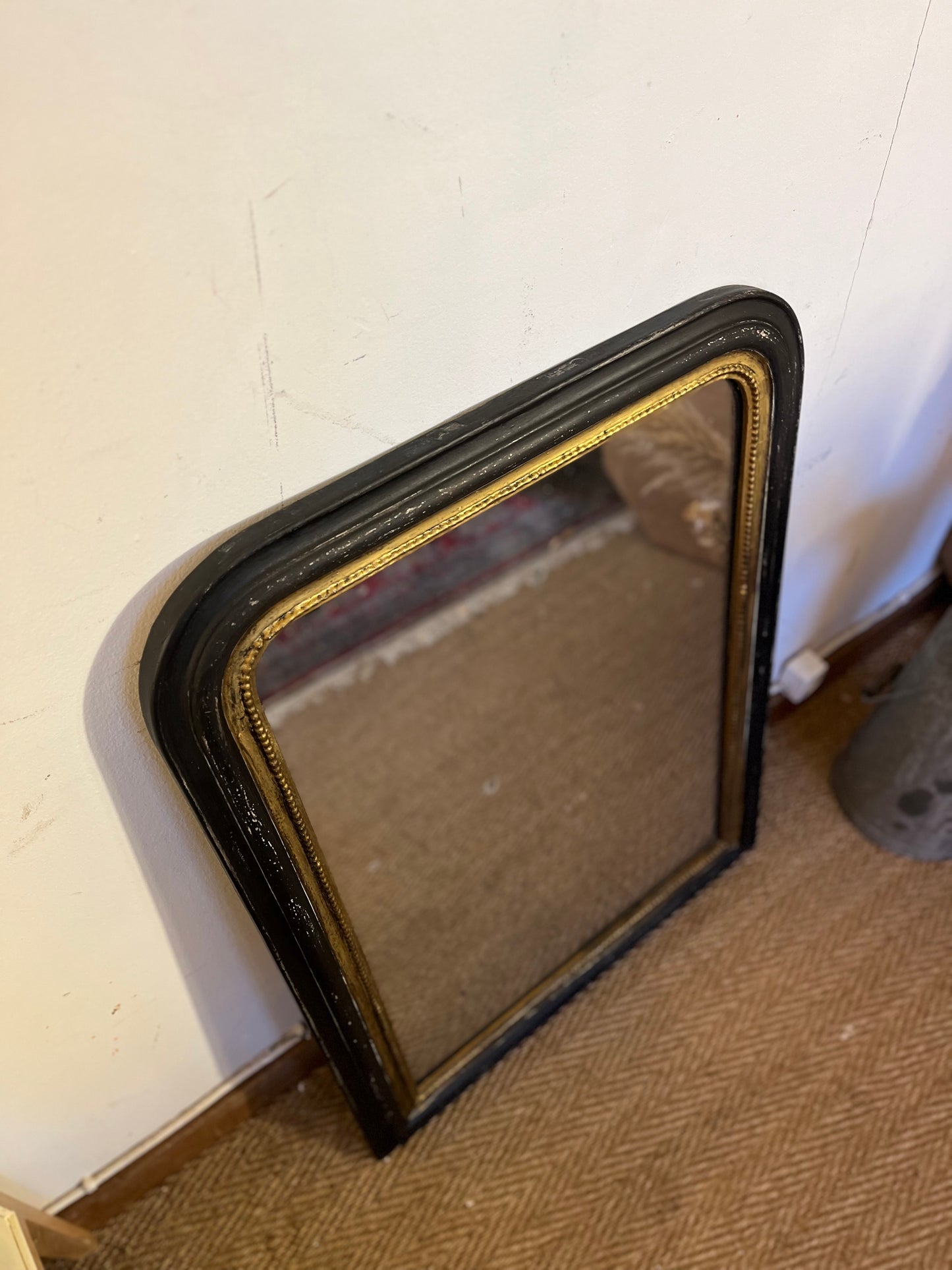 Miroir Louis Philippe ancien en bois et stuc dans sa patine noire et dorée